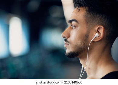 Profile Shot Of Serious Young Arab Man Listening Music In Earphones, Side View Portrait Of Handsome Pensive Middle Eastern Guy Wearing Headphones Standing Indoors, Selective Focus, Copy Space