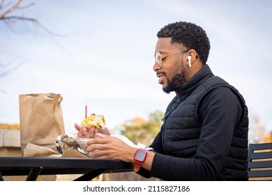 A Profile Shot Of A Stylish African American Man Living With HIV Eating His Lunch Outdoors