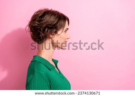 Profile shot of young charming lady looking confident at empty space wear green shirt hairdresser model isolated on pink color background
