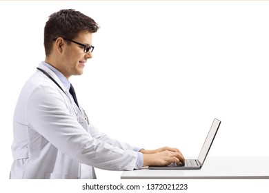 Profile Shot Of A Young Male Doctor Sitting And Working On A Laptop Isolated On White Background