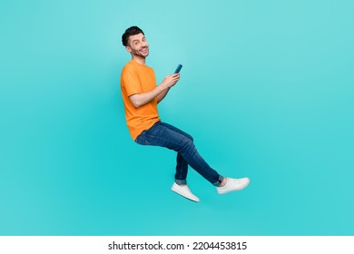 Profile side full body photo of positive guy sit invisible chair blogging device isolated on cyan color background - Shutterstock ID 2204453815