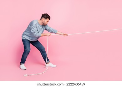 Profile side full length photo of determined guy ready pull string tug war conflict isolated on pastel color background