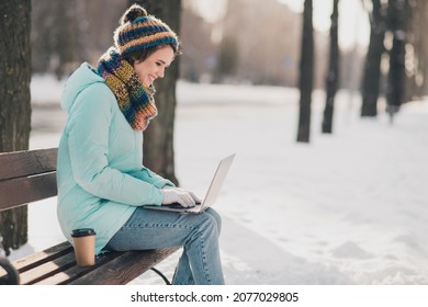 Profile side photo of attractive cheerful young woman sit bench chat laptop freezing in park outdoors outside