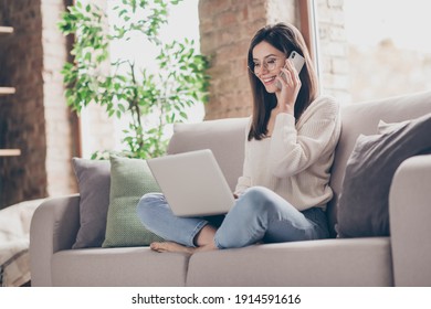 Profile side photo of brown haired woman talk phone listen use laptop wear glasses stay home sit sofa indoors house - Powered by Shutterstock