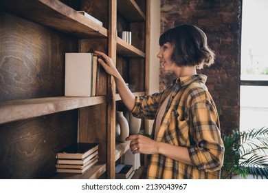 Profile side photo of charming positive lady pick favorite book to read use home library spend free time weekend at home house