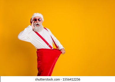 Profile side photo of crazy funky white beard hair santa claus in hat hold big size pants lose weight x-mas celebrate noel diet effect scream isolated yellow color background - Powered by Shutterstock