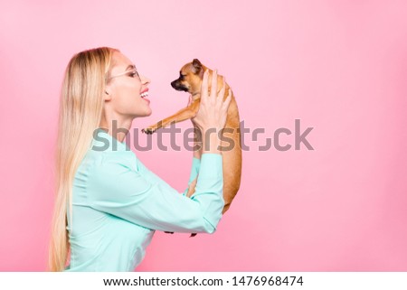 Profile side photo of cute lady holding her chihuahua speaking wearing mint-colored shirt isolated over pink background