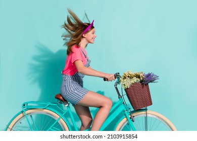Profile side photo of kid cyclist ride home village bike flower basket wear striped t-shirt shorts isolated on cyan color background