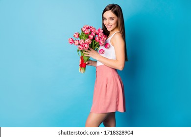 Profile side photo of lovely pretty girlish lady hold big tulips bunch she get on 8-march 14-february dating from her boyfriend wear good look singlet isolated over blue color background