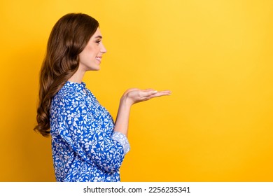 Profile side photo of positive cute stylish lady promoting shampoo balm am hold empty space isolated on yellow color background - Shutterstock ID 2256235341