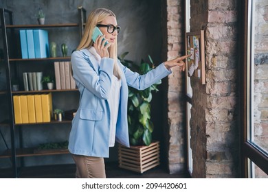 Profile Side Photo Of Worried Chief Lady Listen Partners Speak Smart Phone Miss Appointment Point Finger Noticeboard In Modern Workspace