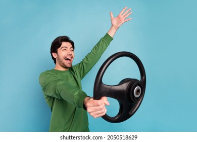 Profile side photo of young amazed crazy guy riding car fast speed extreme riding wheel isolated on blue color background