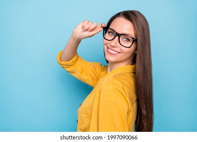 Profile side photo of young attractive pretty girl happy positive smile hand touch eyeglasses cool isolated over blue color background - Powered by Shutterstock