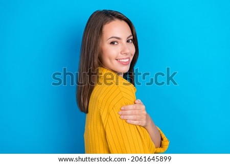 Profile side photo of young beautiful cheerful girl hand touch shoulder isolated over blue color background