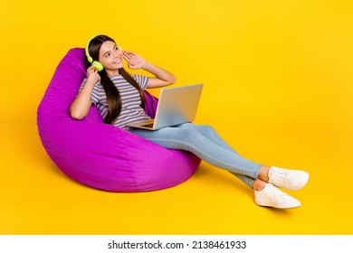 Profile side photo of young girl dreamy enjoy radio headphones laptop cozy rest isolated over yellow color background - Powered by Shutterstock