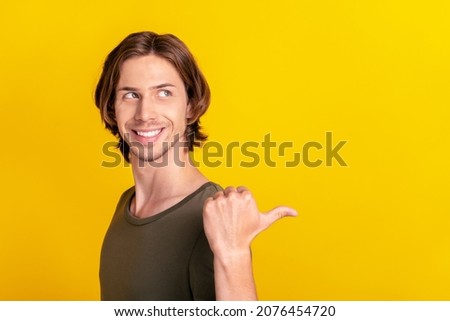 Profile side photo of young interested guy look point thumb empty space promo discount isolated over yellow color background