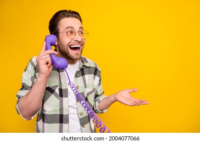 Profile side photo of young man happy positive smile speak call talk phone cord look empty space isolated over yellow color background - Powered by Shutterstock