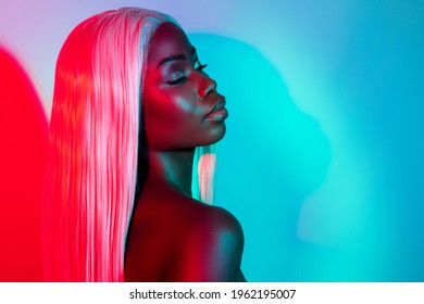 Photo sensuelle du profil de jeune femme séduisante et calme afro, séduisante et paisible, en perruque blonde, isolée sur fond coloré