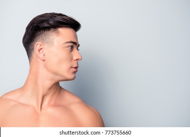 Profile side view half-faced close up portrait of confident handsome shaven with flawless skin man without shirt, isolated on grey background, copyspace