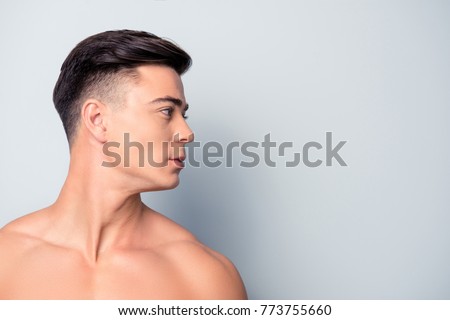 Profile side view half-faced close up portrait of confident handsome shaven with flawless skin man without shirt, isolated on grey background, copyspace