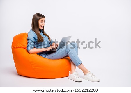 Profile side view of her she nice attractive lovely charming cheerful cheery girl sitting in bag chair using laptop isolated over light white color background
