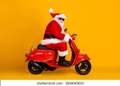Profile side view of his he nice funny thick white-haired Santa riding motor bike fast speed hurry up rush sale hat ball fly race rally isolated bright vivid shine vibrant yellow color background