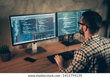 Profile side view of his he nice bearded guy wearing checked shirt professional expert html data base structure screen at wooden industrial interior work place station
