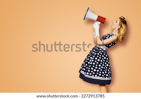 Profile side view image of beautiful woman hold mega phone, shout advertise some offer. Pretty girl in black pin up dress with megaphone loudspeaker. Isolated latte beige background. Big sales ad.