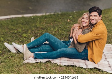 Profile side view portrait of amorous cheerful couple life partners spouses hugging sitting fresh air outdoors