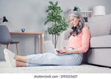 Profile Side View Portrait Of Attractive Serious Focused Woman Using Laptop Sitting On Carpet Floor Typing At Home House Flat Indoor