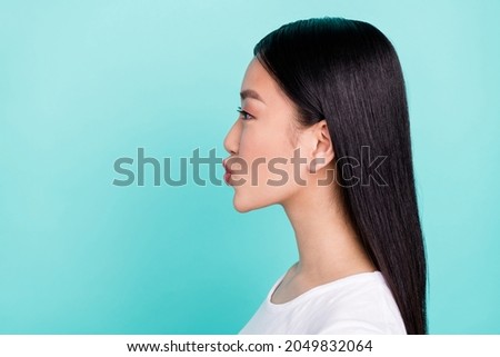 Profile side view portrait of attractive long-haired girl sending air kiss isolated over bright teal turquoise color background