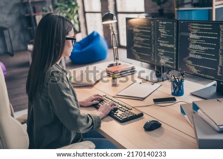 Profile side view portrait of attractive skilled focused girl providing tech support service writing html at workplace workstation indoors