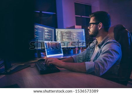 Profile side view portrait of his he nice attractive skilled smart focused concentrated guy consultant writing script creating new digital desktop app in dark room workplace station indoors