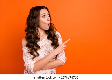 Profile side view portrait of nice attractive lovely winsome pretty cheerful wavy-haired lady in transparent blouse pointing aside copy space isolated over bright vivid shine orange background