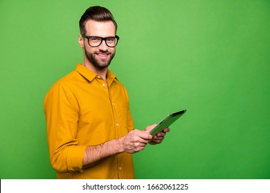 Profile side view portrait of nice attractive cheerful guy in formal shirt holding in hand digital device wi-fi fast speed connection isolated on bright vivid shine vibrant green color background