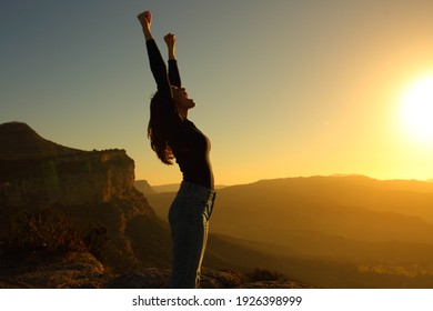 Profile Of A Silhouette Of A Woman Screaming Raising Arms Celebrating Vacation At Sunset In The Mountain