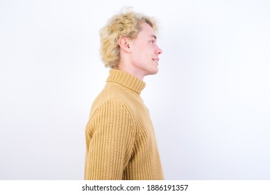 Profile of smiling Young handsome Caucasian blond man standing against white background with healthy skin, has contemplative expression, ready to have outdoor walk. - Powered by Shutterstock