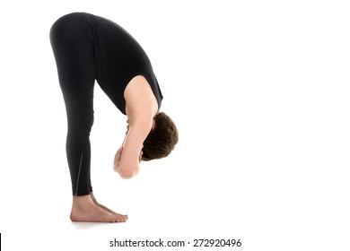 Profile Of Sporty Young Man On White Background In Uttanasana With Elbow Grab (intense Stretch Pose, Forward Bend, Forward Fold, Head To Knees), Dangling Yin Pose, Surya Namaskar Complex