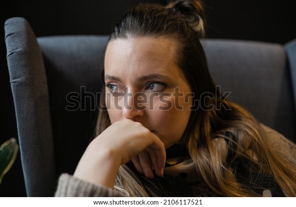 Profile of stressed woman 40 years old sitting near\
window thinking. female person with depressed look in life crisis.\
Causian sad lonely lady