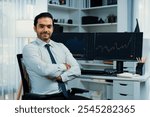 Profile of successful in trader businessman looking at camera with two stock exchange investment screens with good-looking pose in dynamic financial technology graph stock market at office. Surmise.