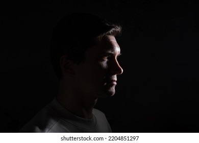 profile of thoughtful man looks to the right. portrait in side light, hard light, photo on black - Powered by Shutterstock