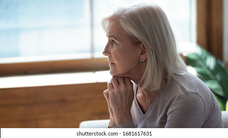 Profile Unhappy Upset Older Woman Sitting Alone And Thinking About Problems, Feeling Lonely, Suffering From Depression, Dementia Or Mental Disorder, Frustrated Mature Female Looking In Distance