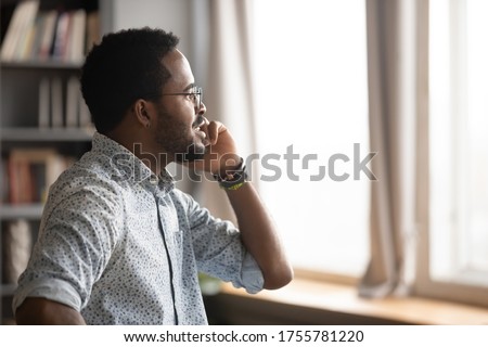 Profile view African ethnicity businessman sales manager talk with customer solving issues distantly during busy workday in office. Client receive consultation from bank manager by phone call concept