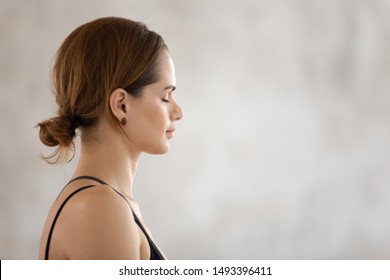 Profile View Beautiful Woman With Closed Eyes Practicing Yoga, Meditating, Attractive Girl Wearing Black Sportswear Relaxing, Meditating In Yoga Studio Or At Home, Stress Relief Close Up