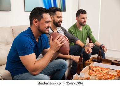 Profile View Of A Bunch Of Guys Watching An American Football Game On TV While Eating Pizza And Drinking Some Beer