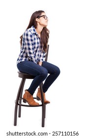 Profile View Of A Cute Hipster Girl Sitting On A Chair And Looking Towards Copy Space