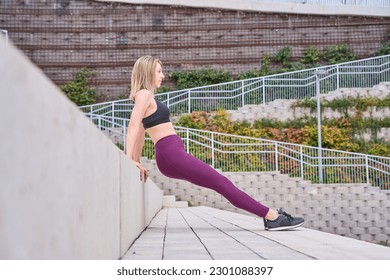 Profile view of a female athlete doing some tricep dips on a bench - Powered by Shutterstock