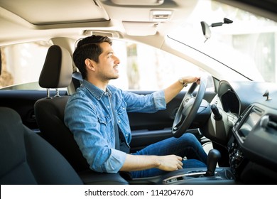 Profile View Of Handsome Young Man Driving His Car On City Street