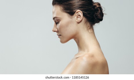 Profile View Of Pretty Young Woman Topless. Beautiful Caucasian Woman Against Grey Background With Eyes Closed.