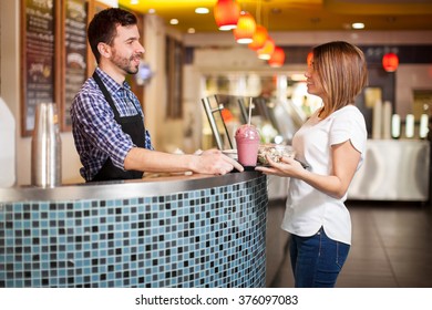 Profile View Of A Restaurant Employee Giving A Tray Full Of Food To A Female Customer